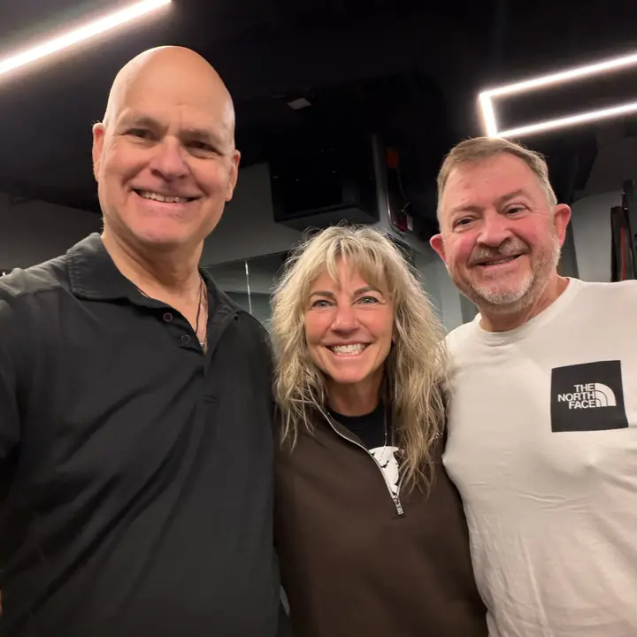 Three friends smiling together in the gym