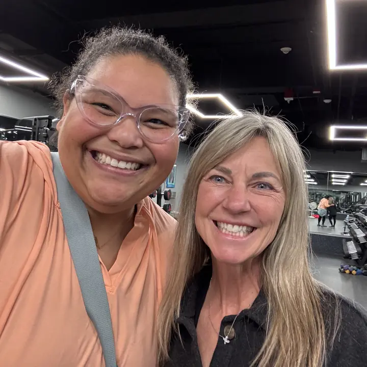 Two women smiling in a selfie at the gym